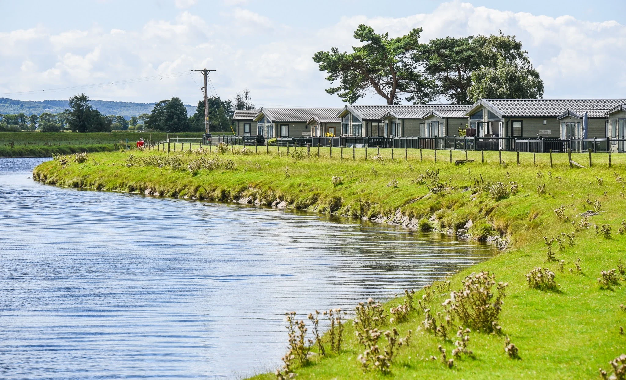 pure leisure parks - riverside picture with holiday homes alongside