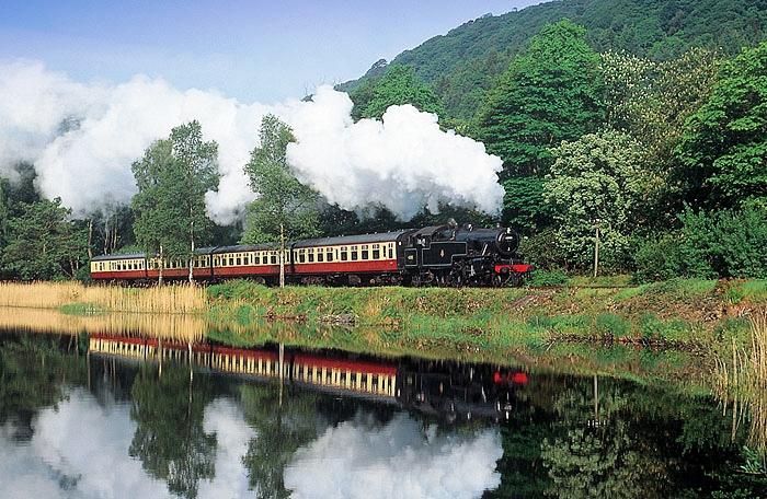 A steam train on the Lakeside and Haverthwaite Railway passing through the Leven Valley countryside